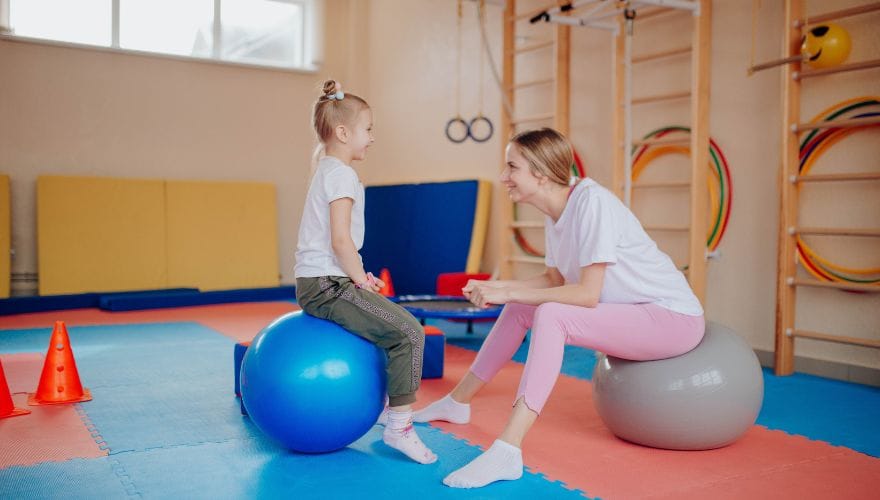 a girl and a woman sitting on the balance balls